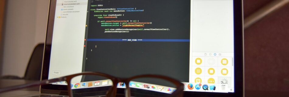 eyeglasses on turned on laptop