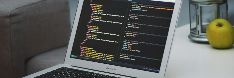 turned on MacBook Air beside saucer with cake on table